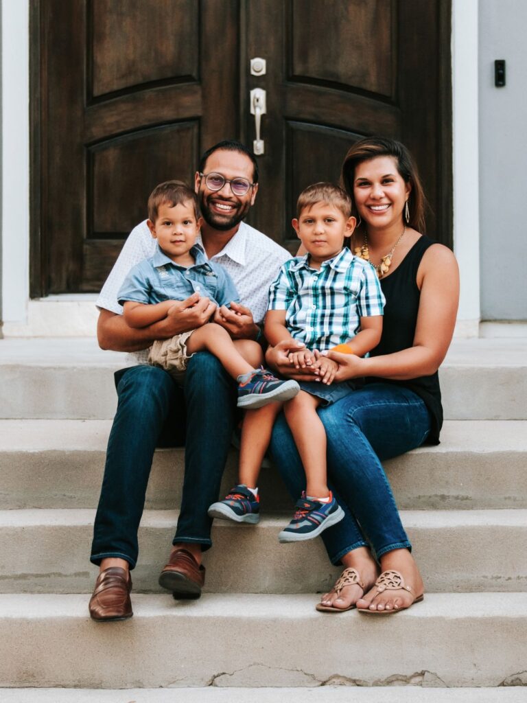 The Patel Family sitting on steps in front of a door